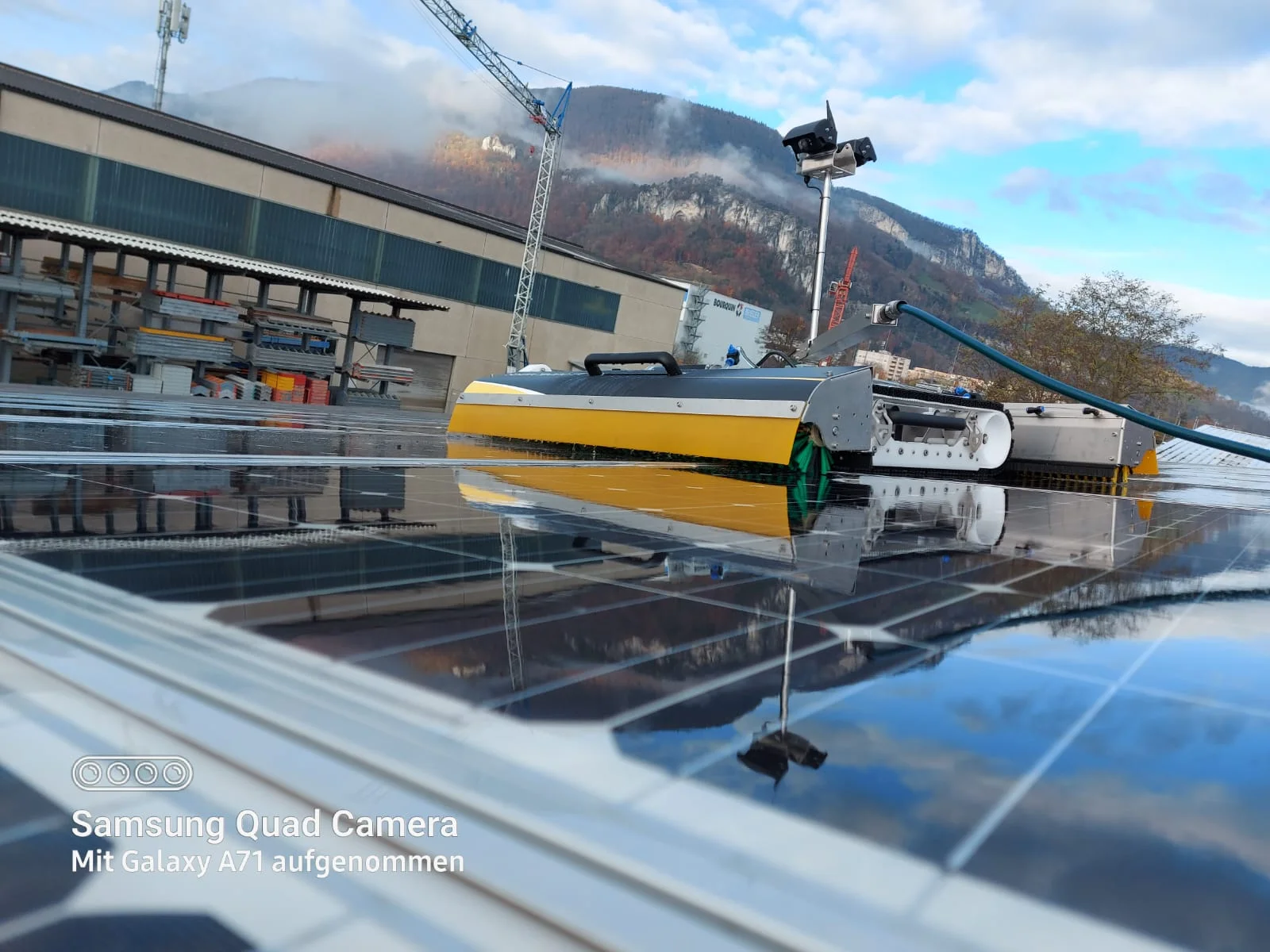 Reinigungsroboter auf den Solarmodulen eines grossen Hallendachs