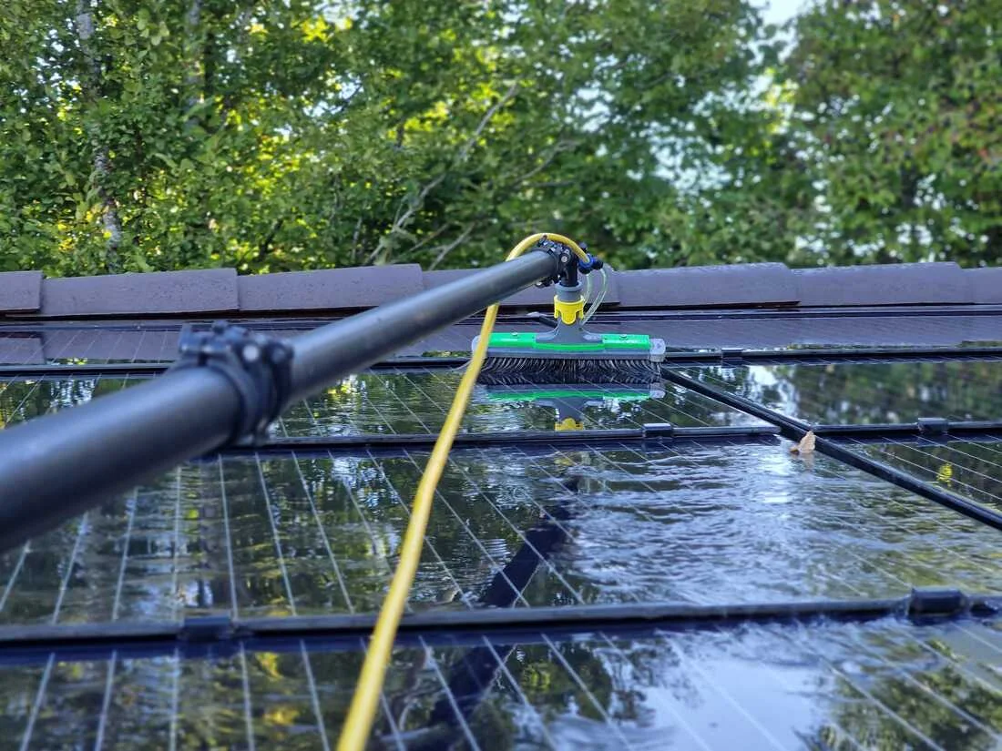 Reinigungsbürste auf Solarmodulen eines Wohngebäudes