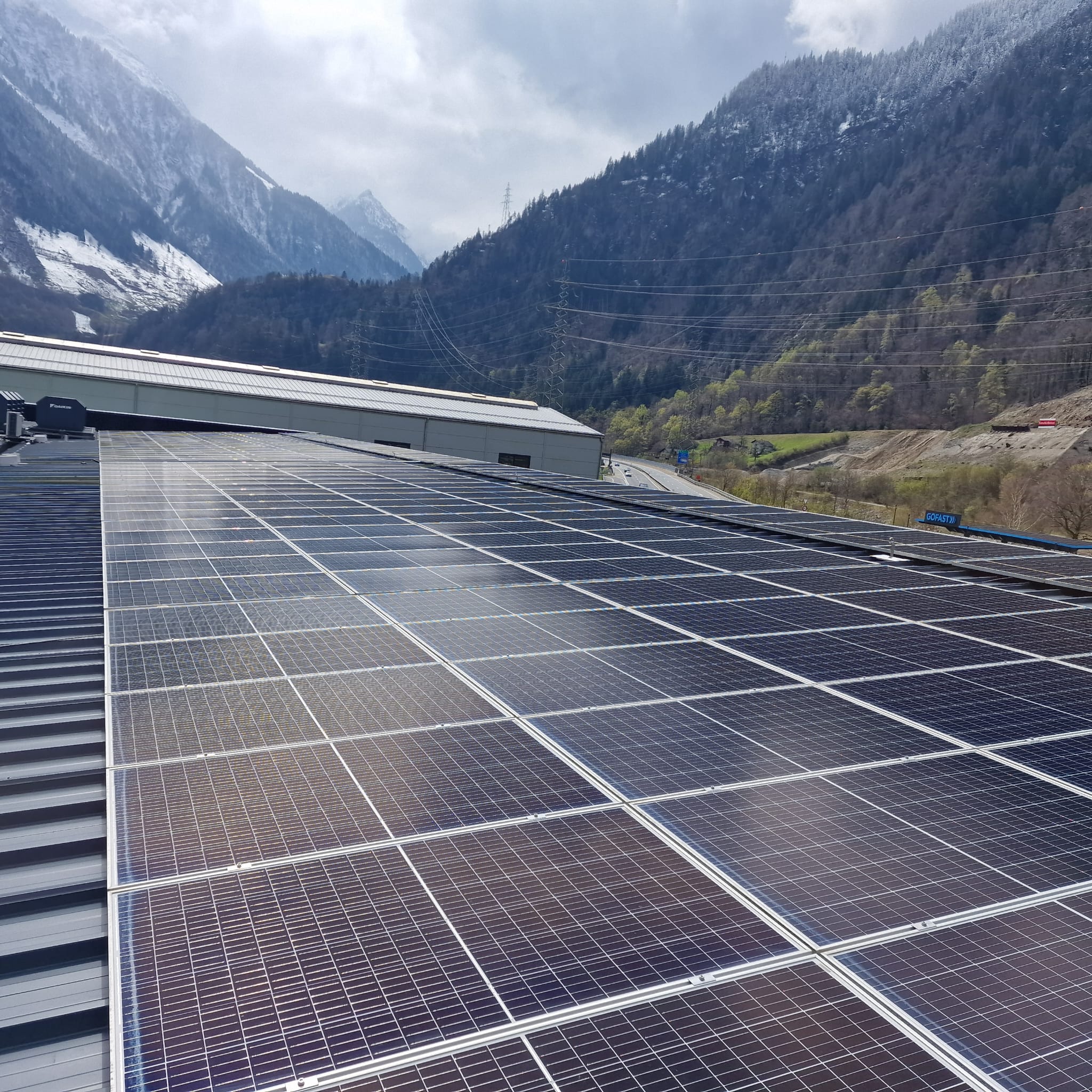 Reihen von Solarmodulen auf einem grossen Industriedach im Tessin